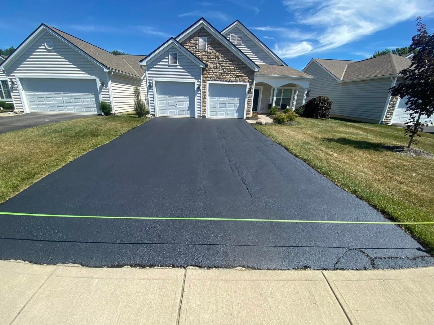 Freshly seal coated asphalt driveway at a two-garage home in Pickerington, Ohio