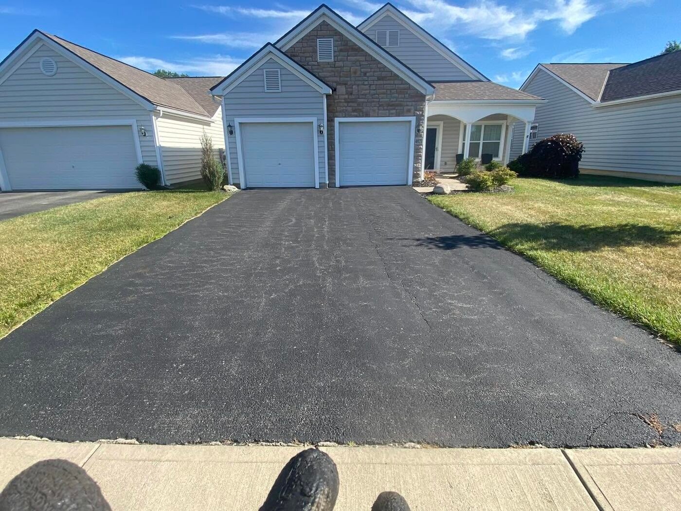 Faded gray asphalt driveway with surface cracking before seal coating, Pickerington Ohio